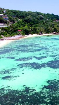 Vertical aerial view of Anse Royale in Seychelles showing turquoise Indian Ocean water, white sandy beach, coral reef and tropical coastal scenery.