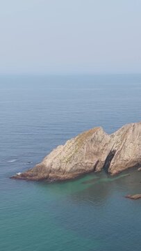 Vertical 9:16 video capturing the dramatic rocky cliffs and turquoise waters at El Peine del Mar, along the coast of Cudillero, Spain.