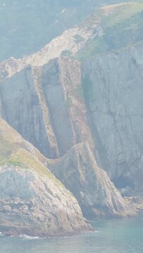 Vertical 9:16 crop showcasing the rugged sea cliffs along the coast near El Peine del Mar in Cudillero, Asturias, Spain.