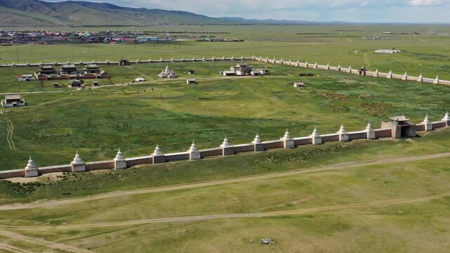 Aerial view of the historic Erdene Zuu Monastery surrounded by its iconic white wall with stupas, set within the vast green steppe landscape of Kharkhorin, Ovorkhangai, Mongolia.