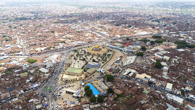 Aerial view of Ilorin Central Mosque with its golden domes and minarets surrounded by dense urban rooftops and busy streets in Oko Erin, Kwara, Nigeria.