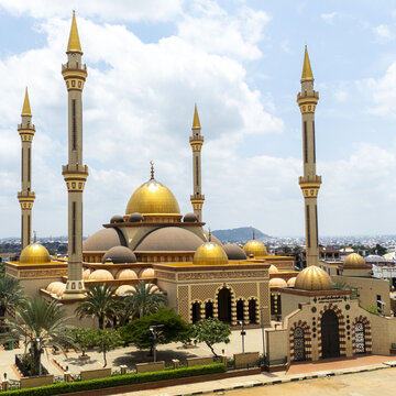 Aerial view of Ilorin Central Mosque featuring its prominent golden domes and tall minarets surrounded by palm trees and lush greenery in Oko Erin, Kwara, Nigeria.