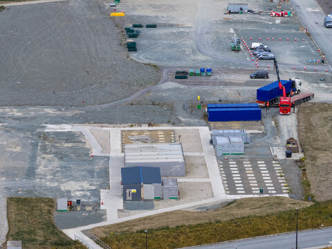 Aerial view of a construction site featuring modular buildings, shipping containers, and a truck with a crane parked on a gravel lot in Drogheda, County Louth, Ireland.