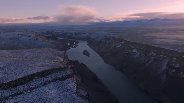 Aerial view of the Morley Nelson Snake River Birds of Prey National Conservation Area with snow-covered canyon cliffs and river at sunset in Murphy, Idaho, United States.