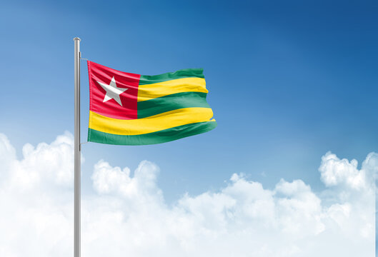 Togo flag waving in beautiful sky.