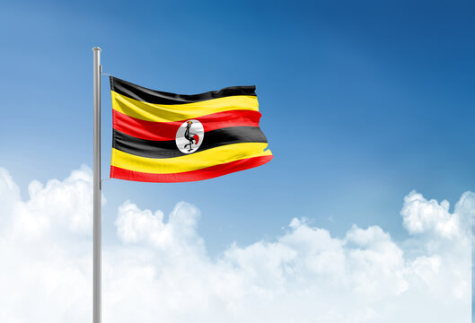 Uganda flag waving in beautiful sky.