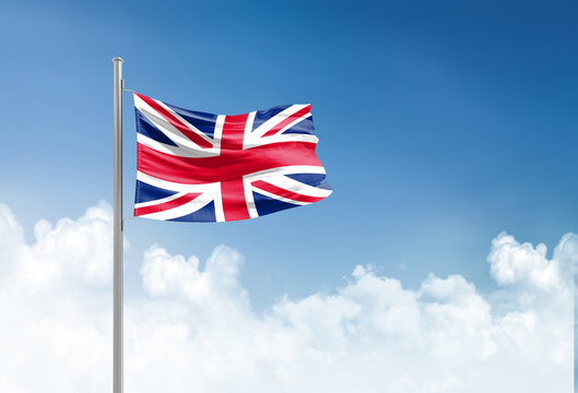 United Kingdom flag waving in beautiful sky.
