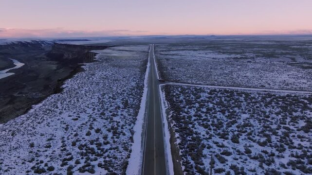 Aerial view of the Morley Nelson Snake River Birds of Prey National Conservation Area with a road cutting through the snow-covered desert landscape in Murphy, Idaho, United States.
