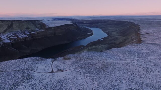 Aerial view of the Snake River winding through the snow-dusted canyon of the Morley Nelson Snake River Birds of Prey National Conservation Area in Murphy, Idaho, United States.