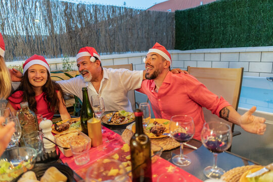 Happy family members laughing during christmas dinner celebration