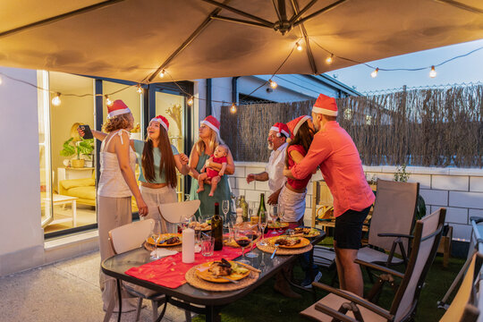 Multi generational family enjoying christmas holiday dinner celebration outdoors