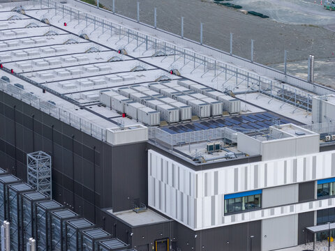 Aerial view of a modern industrial data center facility featuring rooftop HVAC units, solar panels, and metal cladding in Drogheda, County Louth, Ireland.