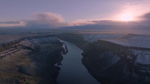 Aerial view of the Snake River winding through the snow-dusted canyon of the Morley Nelson Snake River Birds of Prey National Conservation Area in Murphy, Idaho, United States.