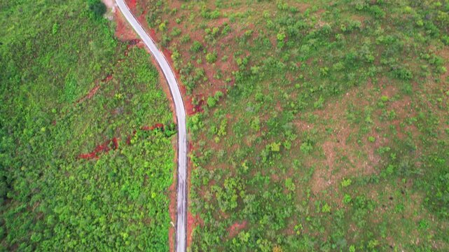 Aerial tilt-up reveal from a winding road to the scenic tropical coastline of Mochima Bay, Venezuela.