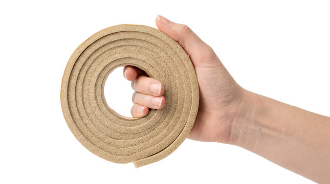 Hand holding a roll of foam weather stripping isolated on transparent background