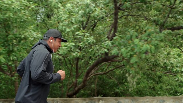 Happy active senior man jogging in nature after retirement. Healthy aging, fitness. Longevity outdoor lifestyle, preventive health, retirement happiness. Life insurance and financial security concept.