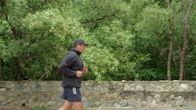 Happy active senior man jogging in nature after retirement. Healthy aging, fitness. Longevity outdoor lifestyle, preventive health, retirement happiness. Life insurance and financial security concept.
