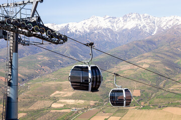 Gondola cable cars crossing valley beneath snowy mountains © Daria