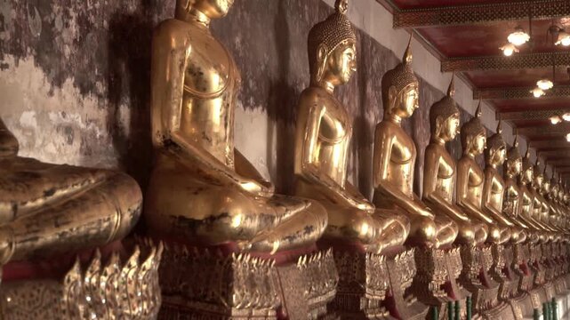 Row of ancient buddha statues in buddhist temple