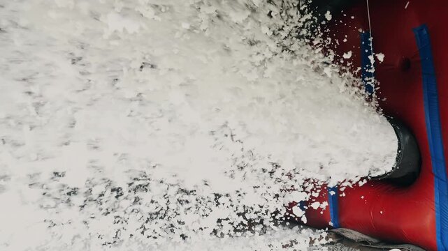 Powerful stream of firefighting foam discharged from fire suppression equipment. Active foam application for fire control, emergency response and safety training.
