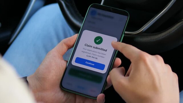 Person submits an insurance claim on a smartphone inside a car, highlighting digital claims processing, mobile insurance services and faster access to financial protection.