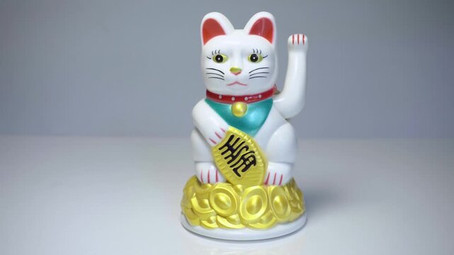 Chinese lucky cat Maneki Neko waving paw decorative figurine close up
