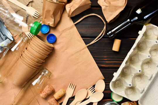 Flat lay of various types of garbage and recycling sign. Eco concept. On wooden background.