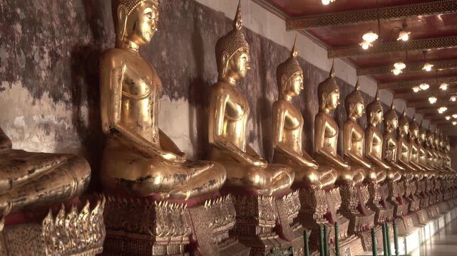 Row of ancient buddha statues in buddhist temple