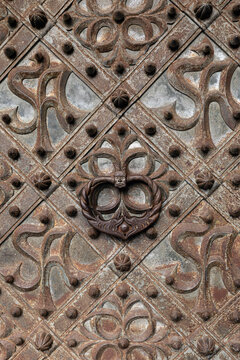 Ornate iron door knocker with face mask on historic gate of St. Anne's Church. Vilnius, Lithuania