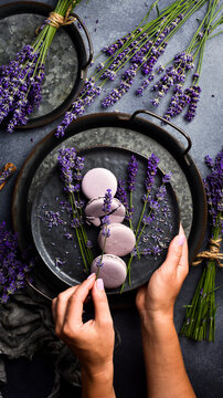 Macaroons and bunch of lavender in female hands. Top view. Free space for text.