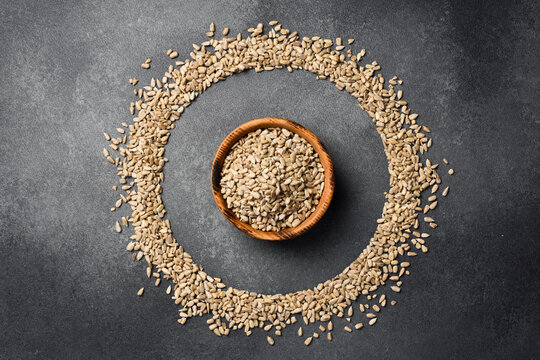 Wooden bowl with peeled sunflower seeds. Close-up. Organic food.