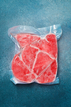 Vacuum packaging with tuna steaks. Raw frozen tuna fillet. Top view.