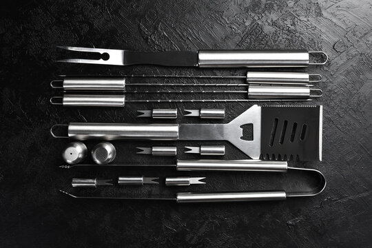 Steel barbecue and grill set. On a black slate table. Top view.