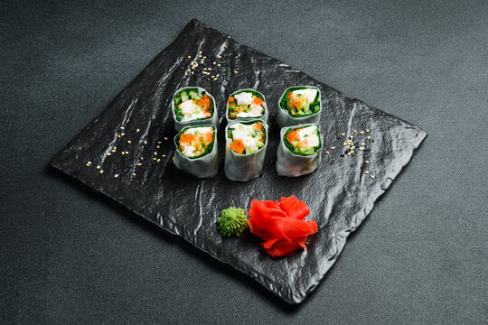 Traditional fresh Japanese sushi rolls with shrimp in a rice sheet. Served with wasabi sauce and pickled ginger. Close up.