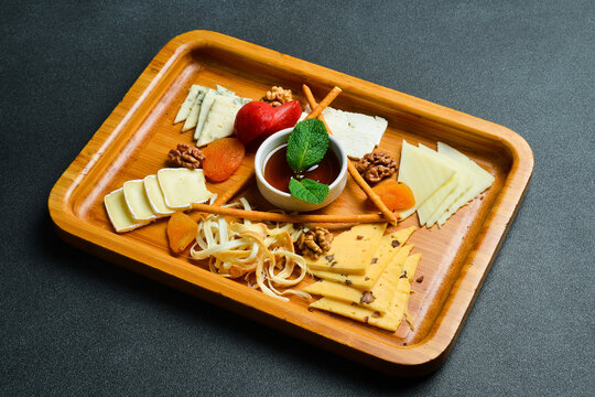 Cheese slice. Cheese plateau. On a dark slate background.