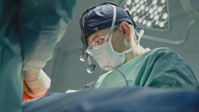Two doctors operating in modern innovative clinic surgeon therapist assistant operation together using surgical tools medical team operate laparoscopy surgery organ transplantation medicine procedure