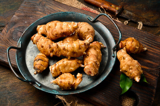 Fresh organic Jerusalem artichoke in a bowl. Side view. Close-up.