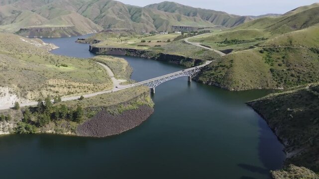 Aerial view of Lucky Peak Lake and its bridge surrounded by rolling hills and calm water in Ada County, Idaho, United States.