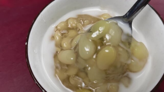 Close up of traditional Vietnamese hyacinth bean sweet soup with coconut milk in a bowl