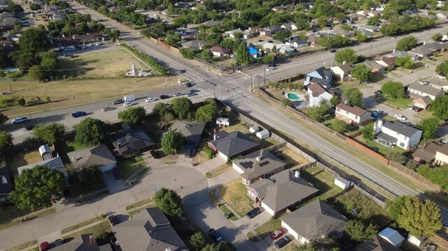 Paved turnaround cul de-sacs border Southeast Parkway commuter corridor near Charles City tract. Single family brick houses face tree lined streets, sunny front lawns, Arlington, Texas