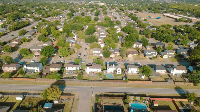 Fenced backyard swimming pools border Southeast Parkway commuter route near Charles City tract. Two story suburban homes line quiet residential cul de-sacs, paved roads, Arlington, Texas