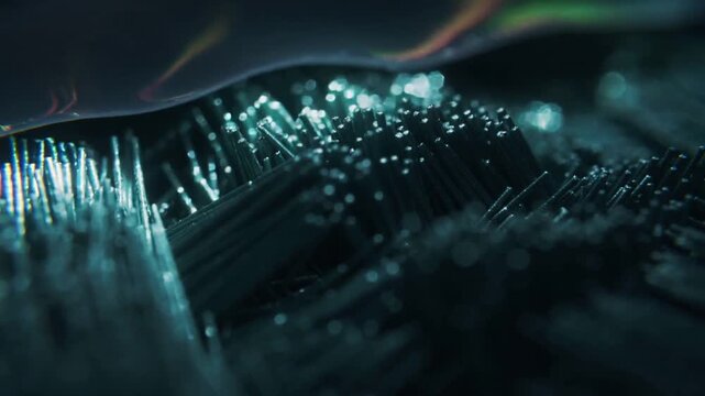 Light cue causing iridescent sheet shifting above filament bed in macro studio revealing tip glints