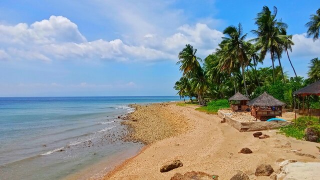 Beautiful tropical beach in the Philippines with traditional nipa hut, coconut palm trees, white sand and clear blue ocean. Perfect for summer vacation, travel and tourism concept .