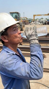 Construction worker drinking water from bottle