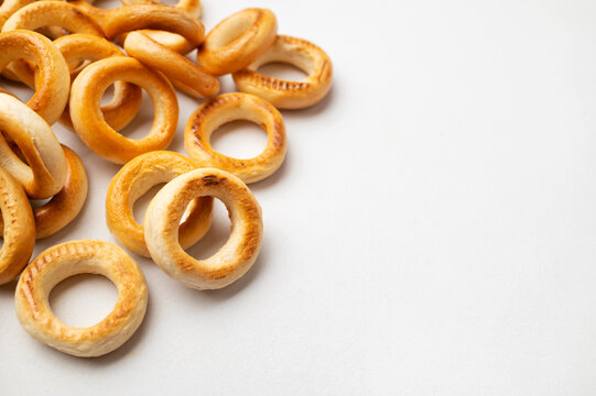 Scattered bread rings on light gray surface offer overhead food backdrop with open copy space. Wheat snacks suit tea concepts, bakery promotion, breakfast visuals, packaging and editorial design.