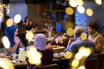 Fototapeta premium Muslim Family Dinner Celebration With Multi-Generational Relatives Sharing Joyful Evening Meal