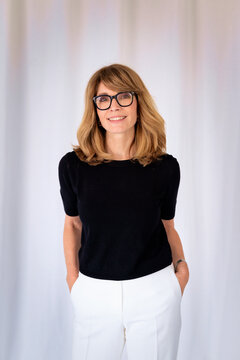 Smiling businesswoman with blond haired looking at camera and smiling against isolated background