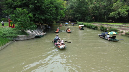High angle view of tourist boats rowing along winding river amidst limestone karst mountains in Tam Coc, Vietnam © GeoWild
