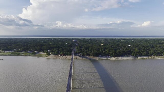 Aerial drone footage showing Haripur Bridge extending across the Gorai River in Kushtia, Bangladesh, with the wide river and green riverside landscape visible on both sides.