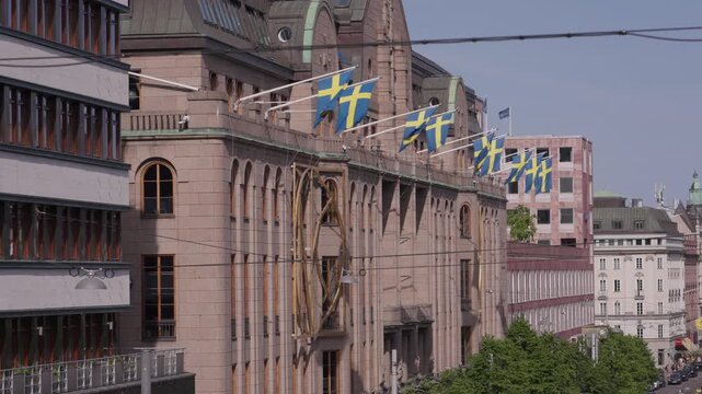 Sweden flags sticking out on side of building. Swedish national flags on the facade of the Nordiska Kompaniet (NK) department store. Stockholm, Sweden
